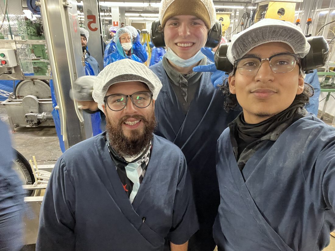 Chel with coworkers on the processing floor in Alaska